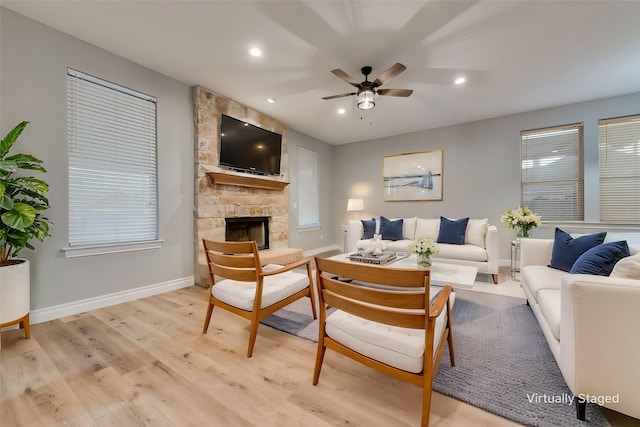 living room with baseboards, recessed lighting, light wood-style floors, ceiling fan, and a fireplace
