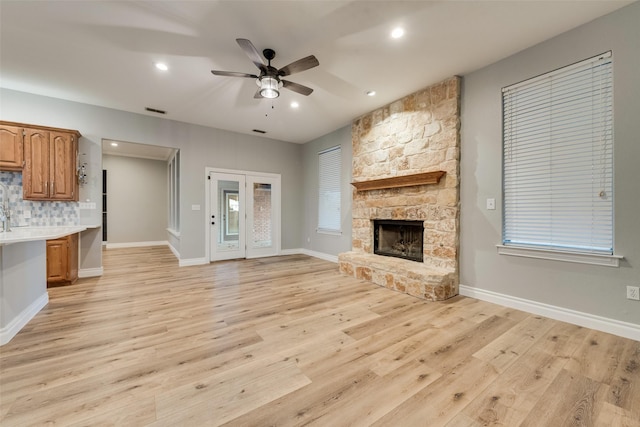 unfurnished living room featuring light wood-type flooring, visible vents, recessed lighting, a ceiling fan, and a fireplace
