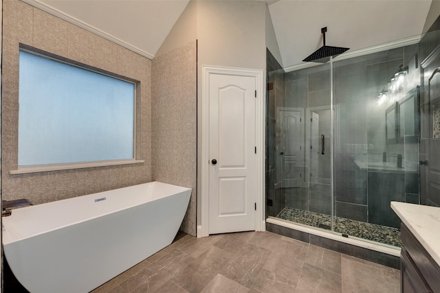bathroom featuring lofted ceiling, vanity, a freestanding tub, and a shower stall
