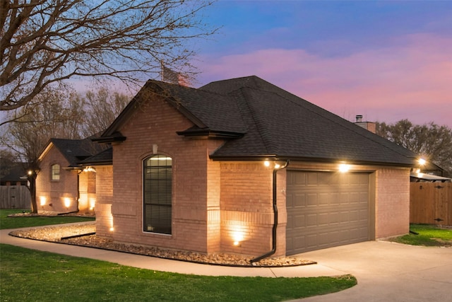 view of front facade featuring a chimney, brick siding, and a shingled roof