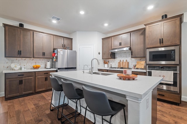 113 Glenwood Dr, Oak Point, TX 75068 - kitchen with appliances with stainless steel finishes, under cabinet range hood, backsplash, dark wood-type flooring, and recessed lighting
