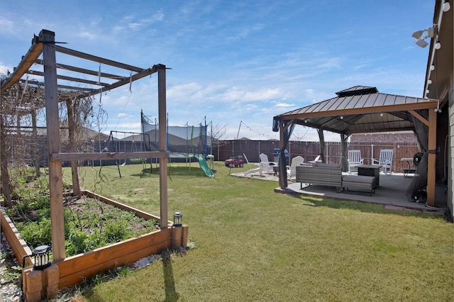 808 Glover Dr, Aubrey, TX 76227 - view of yard featuring a garden, a trampoline, a patio area, a gazebo, and a fenced backyard