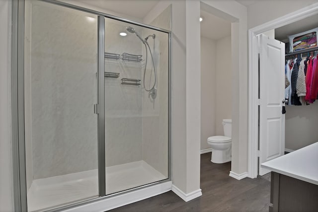 808 Glover Dr, Aubrey, TX 76227 - bathroom featuring wood finished floors, toilet, baseboards, a walk in closet, and a stall shower
