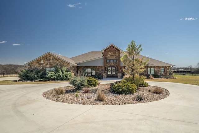 840 N Ash St, Muenster, TX 76252 - view of front facade featuring stone siding, curved driveway, and french doors