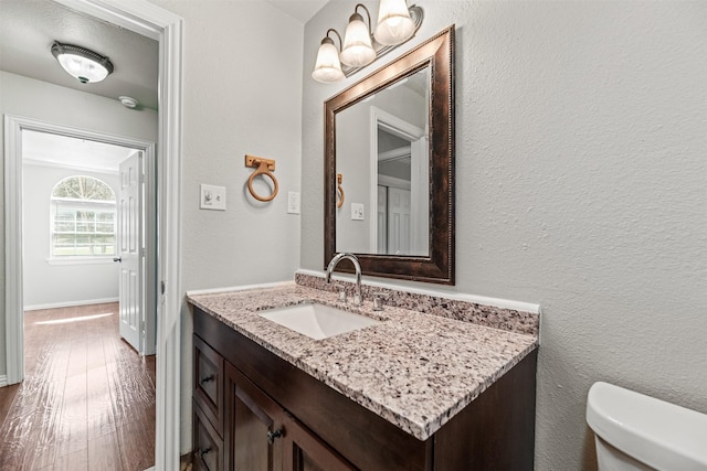4512 Fletcher Ave, Fort Worth, TX 76107 - bathroom with vanity, toilet, wood finished floors, and a textured wall