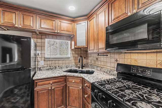 4512 Fletcher Ave, Fort Worth, TX 76107 - kitchen featuring a sink, decorative backsplash, light stone countertops, and black appliances