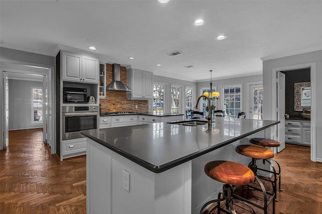 9702 Trail Hill Dr, Dallas, TX 75238 - kitchen with visible vents, a sink, stainless steel appliances, dark countertops, and wall chimney range hood
