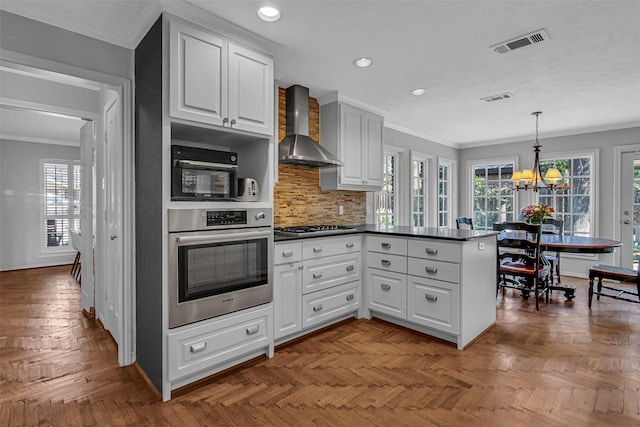 9702 Trail Hill Dr, Dallas, TX 75238 - kitchen with a peninsula, wall chimney exhaust hood, visible vents, and stainless steel appliances