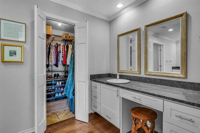 9702 Trail Hill Dr, Dallas, TX 75238 - bathroom featuring vanity, wood finished floors, recessed lighting, ornamental molding, and a walk in closet