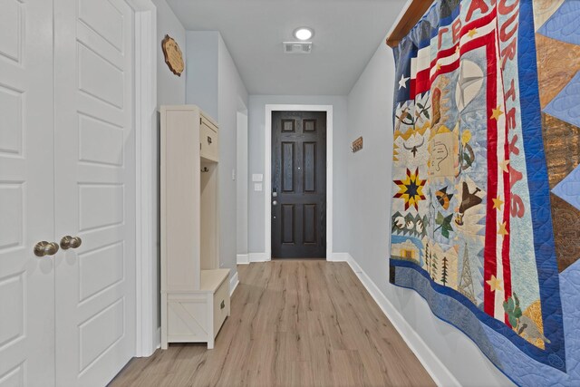 interior space featuring visible vents, light wood-style flooring, and baseboards