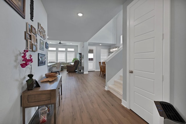 corridor with recessed lighting, stairs, wood finished floors, and baseboards