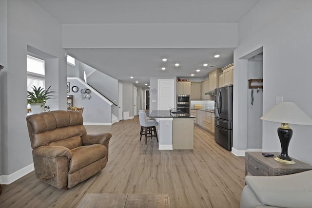 living area with stairway, light wood-type flooring, recessed lighting, and baseboards