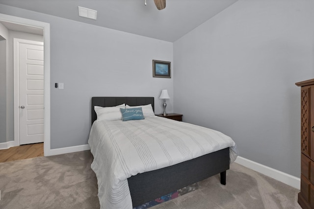 carpeted bedroom with visible vents, vaulted ceiling, and baseboards