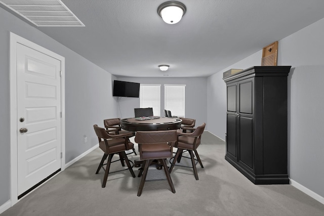 dining area with light colored carpet, visible vents, and baseboards