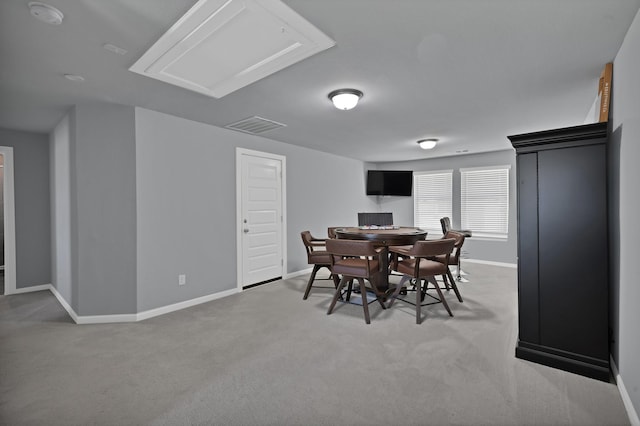 dining space featuring light colored carpet, visible vents, and baseboards