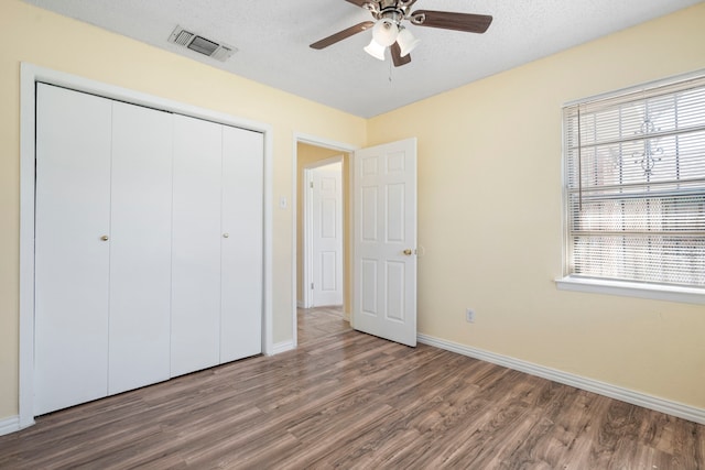 7918 Racine Dr, Dallas, TX 75232 - unfurnished bedroom featuring a closet, visible vents, multiple windows, and wood finished floors