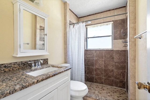 7918 Racine Dr, Dallas, TX 75232 - full bath featuring a stall shower, toilet, vanity, and a textured ceiling