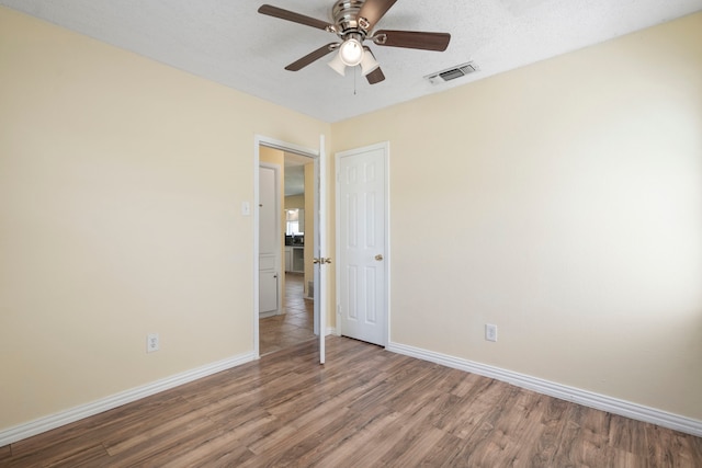 7918 Racine Dr, Dallas, TX 75232 - unfurnished bedroom with visible vents, a ceiling fan, a textured ceiling, wood finished floors, and baseboards
