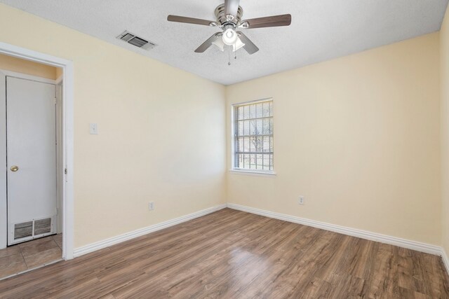 7918 Racine Dr, Dallas, TX 75232 - spare room featuring visible vents, a textured ceiling, wood finished floors, and a ceiling fan
