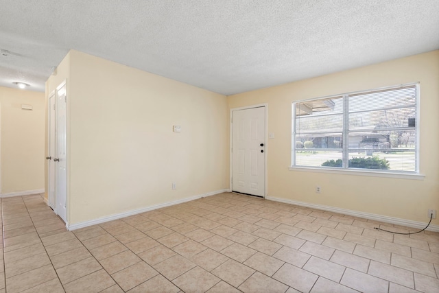 7918 Racine Dr, Dallas, TX 75232 - spare room with light tile patterned floors, a textured ceiling, and baseboards