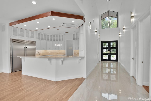 foyer entrance featuring visible vents, baseboards, a high ceiling, and recessed lighting