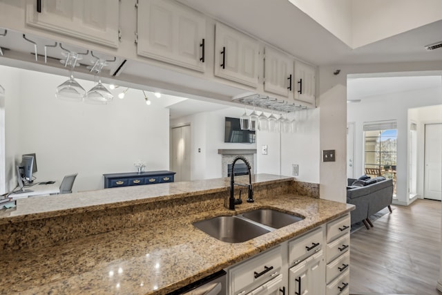 3105 San Jacinto St Unit 304, Dallas, TX 75204 - kitchen featuring white cabinets, light stone countertops, and light wood-style flooring