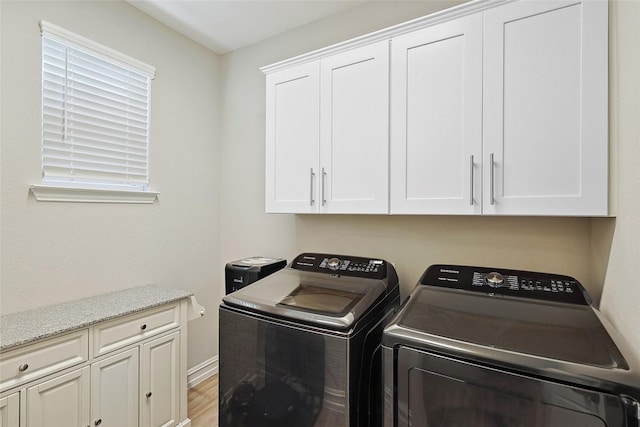 262 Jones St, Irving, TX 75063 - laundry room with washer and clothes dryer, cabinet space, and light wood-style floors