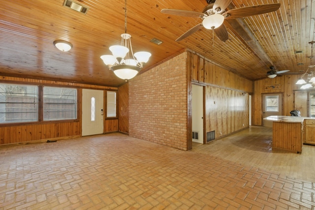 unfurnished living room featuring wooden ceiling, wooden walls, visible vents, and lofted ceiling