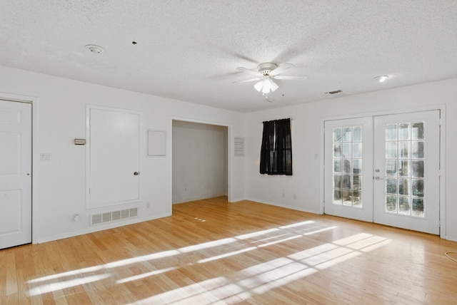 unfurnished bedroom with a textured ceiling, visible vents, light wood-style floors, and french doors