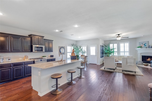 108 Oakmont Dr, Argyle, TX 76226 - kitchen featuring a kitchen bar, dark wood-style floors, appliances with stainless steel finishes, and a sink