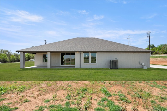 back of house with cooling unit, a patio, brick siding, and a lawn