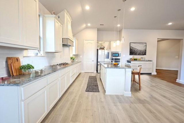 209 Chesapeake Dr, Forney, TX 75126 - kitchen with a center island, appliances with stainless steel finishes, light wood-type flooring, backsplash, and white cabinetry