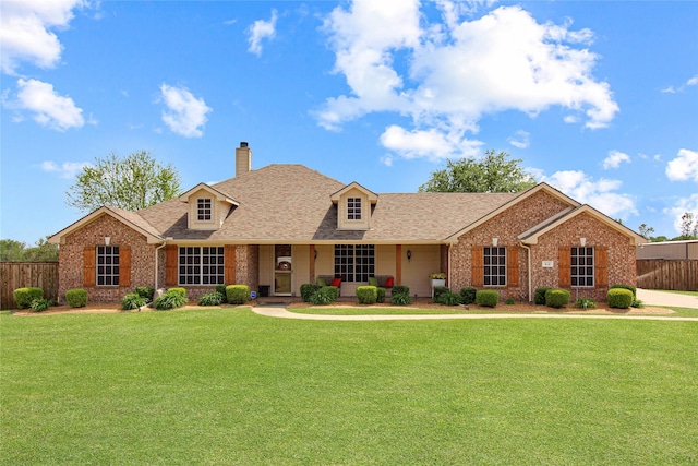view of front of property with a chimney, fence, a shingled roof, and a front yard