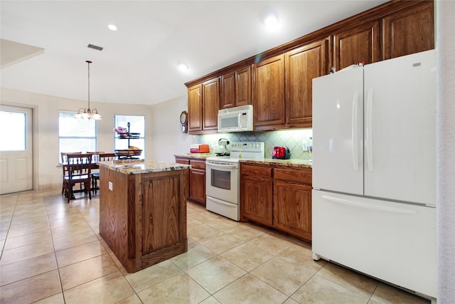 kitchen featuring light stone counters, decorative backsplash, white appliances, an inviting chandelier, and a kitchen island