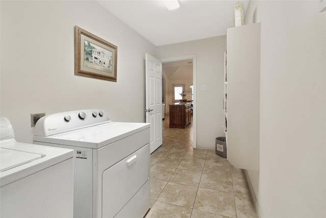 washroom featuring washing machine and clothes dryer, laundry area, and light tile patterned floors