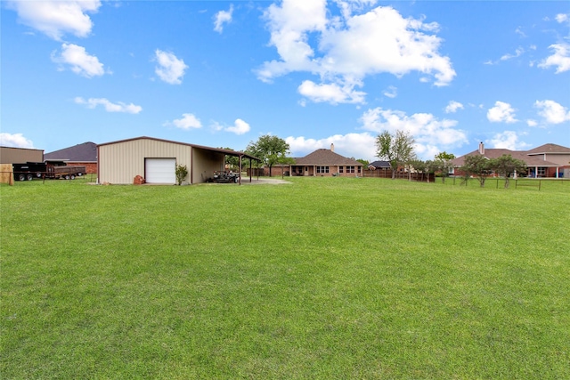 view of yard featuring an outdoor structure, fence, and a detached garage