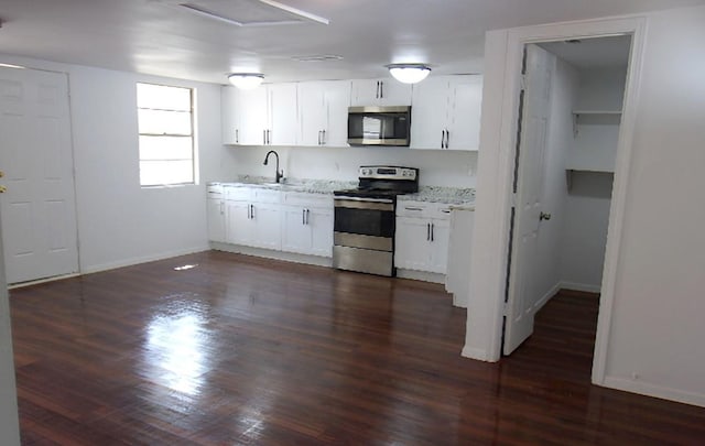 711 Dubois St, Denison, TX 75020 - kitchen featuring white cabinets, stainless steel appliances, dark wood-type flooring, and a sink