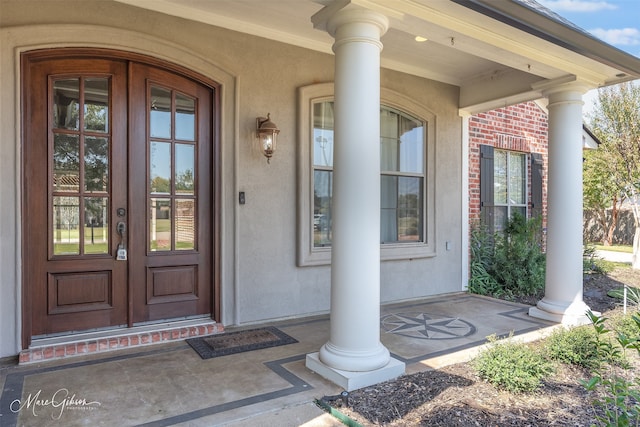 doorway to property featuring a porch and french doors