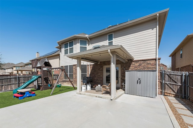2224 Loreto Dr, Fort Worth, TX 76177 - rear view of property featuring a patio area, a playground, a fenced backyard, brick siding, and a gate