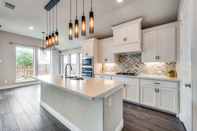 9600 Blue Stem Ln, Little Elm, TX 75068 - kitchen with a sink, appliances with stainless steel finishes, a kitchen island with sink, tasteful backsplash, and white cabinets