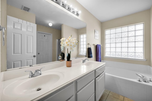 full bath with visible vents, a garden tub, tile patterned flooring, and a sink