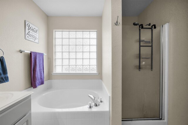full bathroom with a garden tub, a stall shower, and vanity