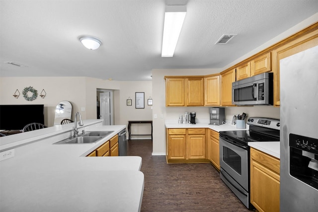 kitchen featuring dark wood finished floors, stainless steel appliances, light countertops, and a sink