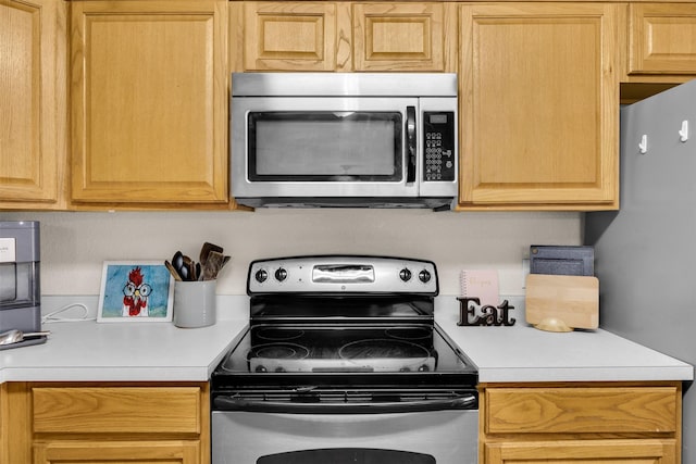 kitchen featuring light brown cabinetry, appliances with stainless steel finishes, and light countertops