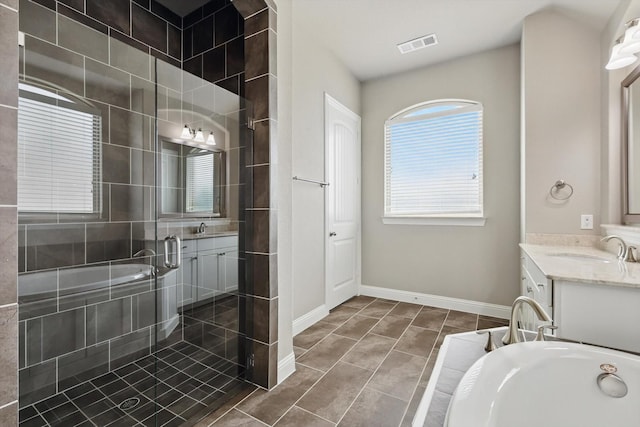 full bath featuring tiled bath, vanity, tile patterned floors, and a stall shower