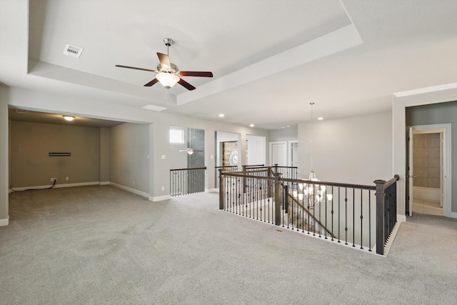 empty room with ceiling fan, carpet flooring, a tray ceiling, and recessed lighting