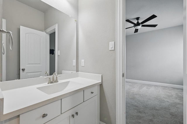 bathroom featuring ceiling fan, vanity, and baseboards