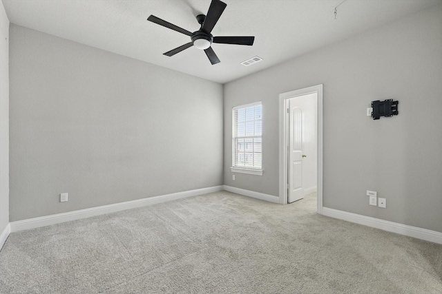 carpeted empty room featuring a ceiling fan and baseboards