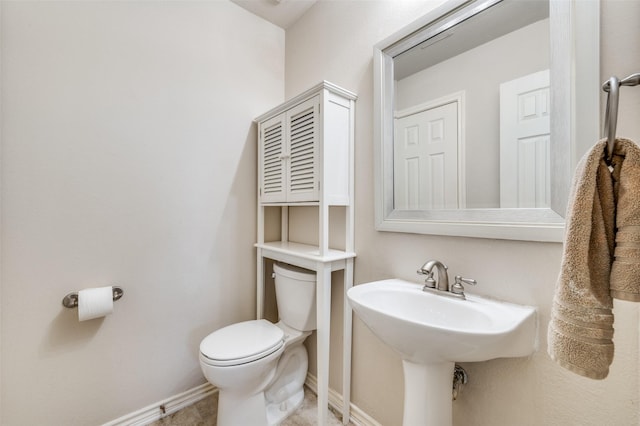 half bathroom with toilet and baseboards