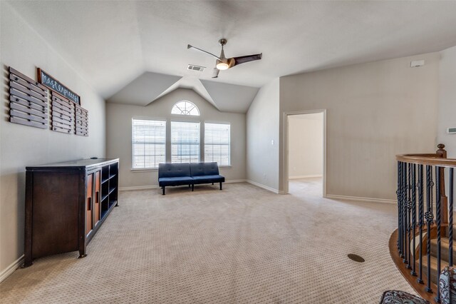 living area with baseboards, visible vents, ceiling fan, and light colored carpet